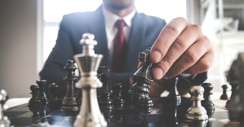 business man with chess pieces represents strategy