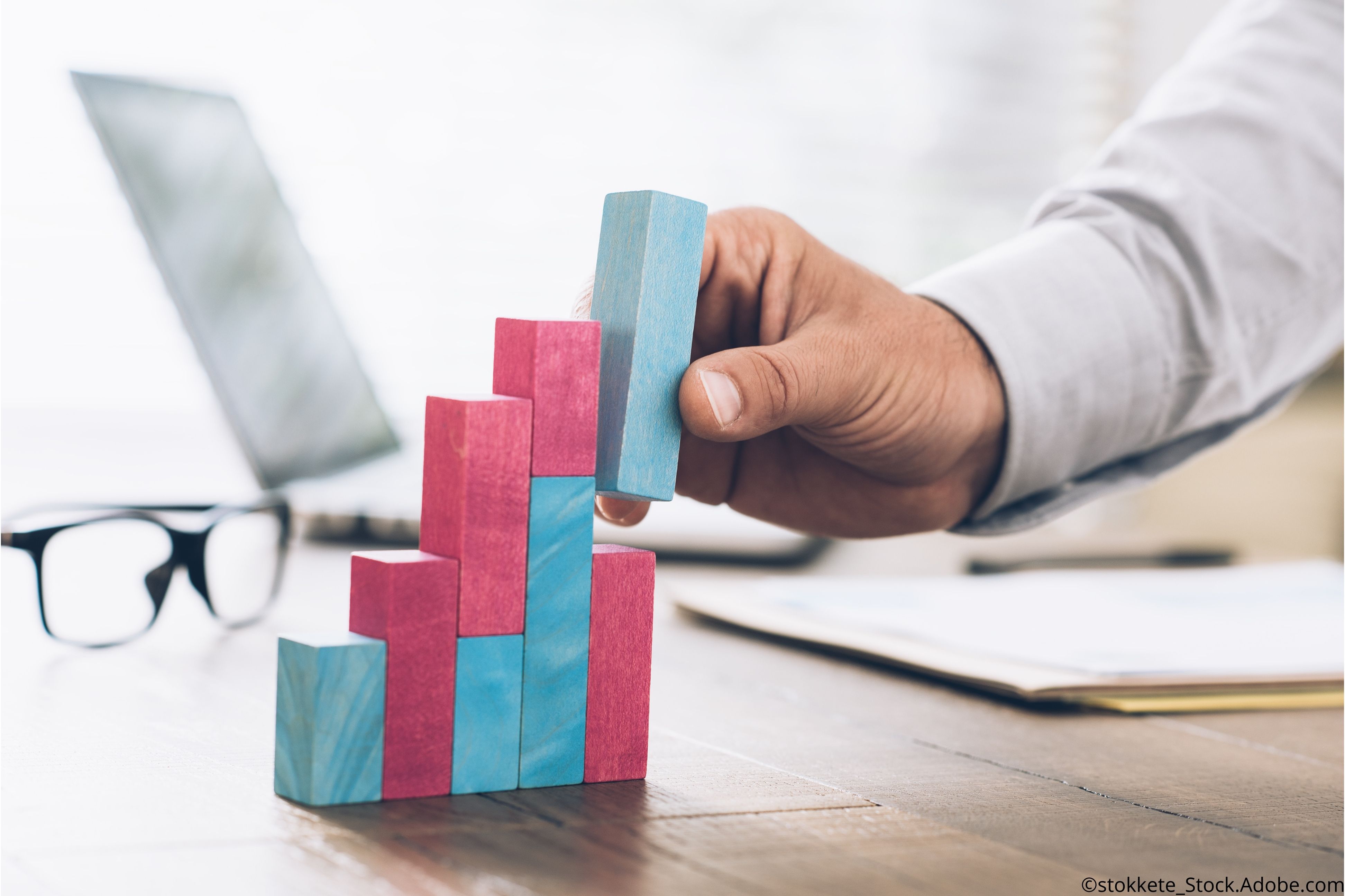 man's hand building blocks in graph form